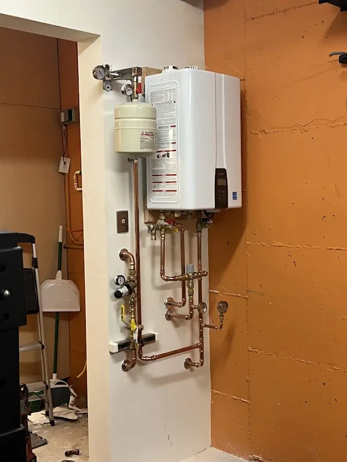 Plumbing technician inspecting water heater connections in Council Bluffs